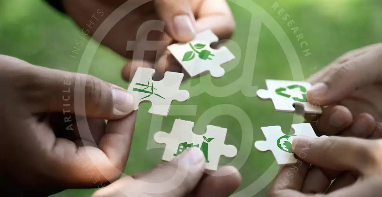 Hands holding puzzle pieces bringing them together with sustainability icons printed on them.